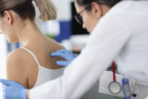 Medical professional examining a woman's spine